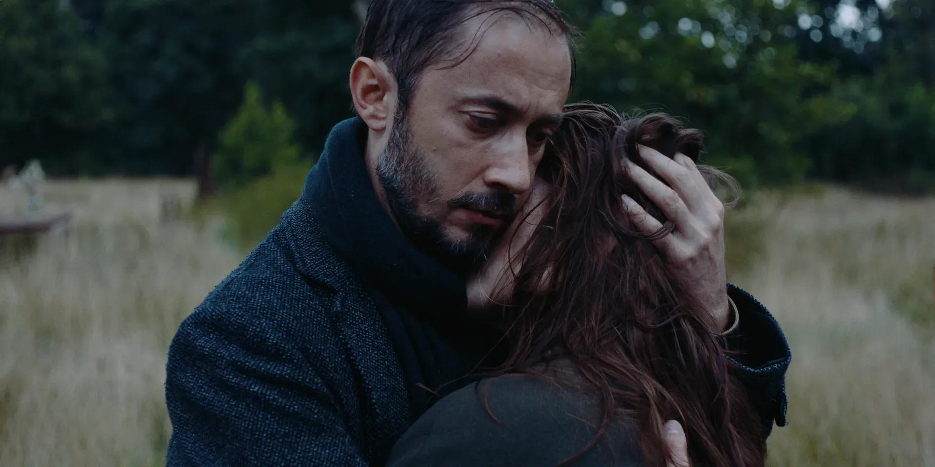 Ana's husband holding her closely in a field in The Tears of Things