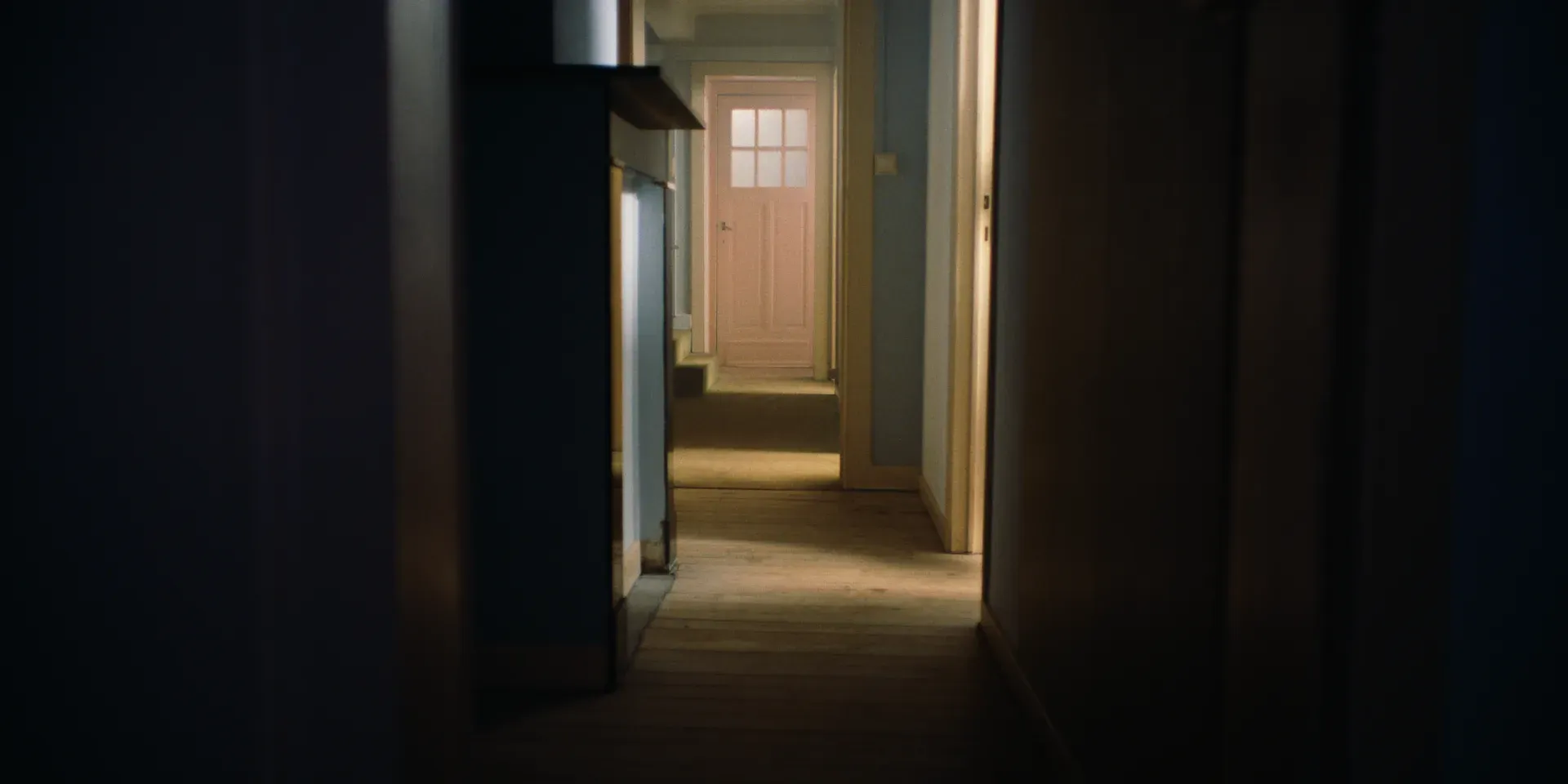 An empty hallway leading to a sunlit door in The Tears of Things