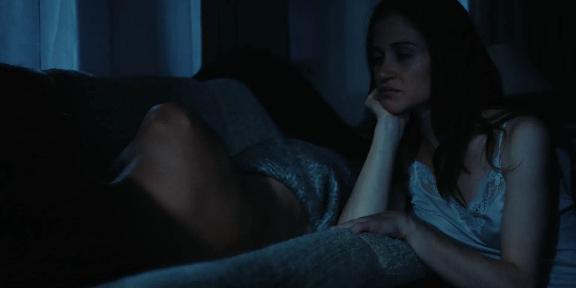 Ana sitting pensively in a white nightdress in The Tears of Things