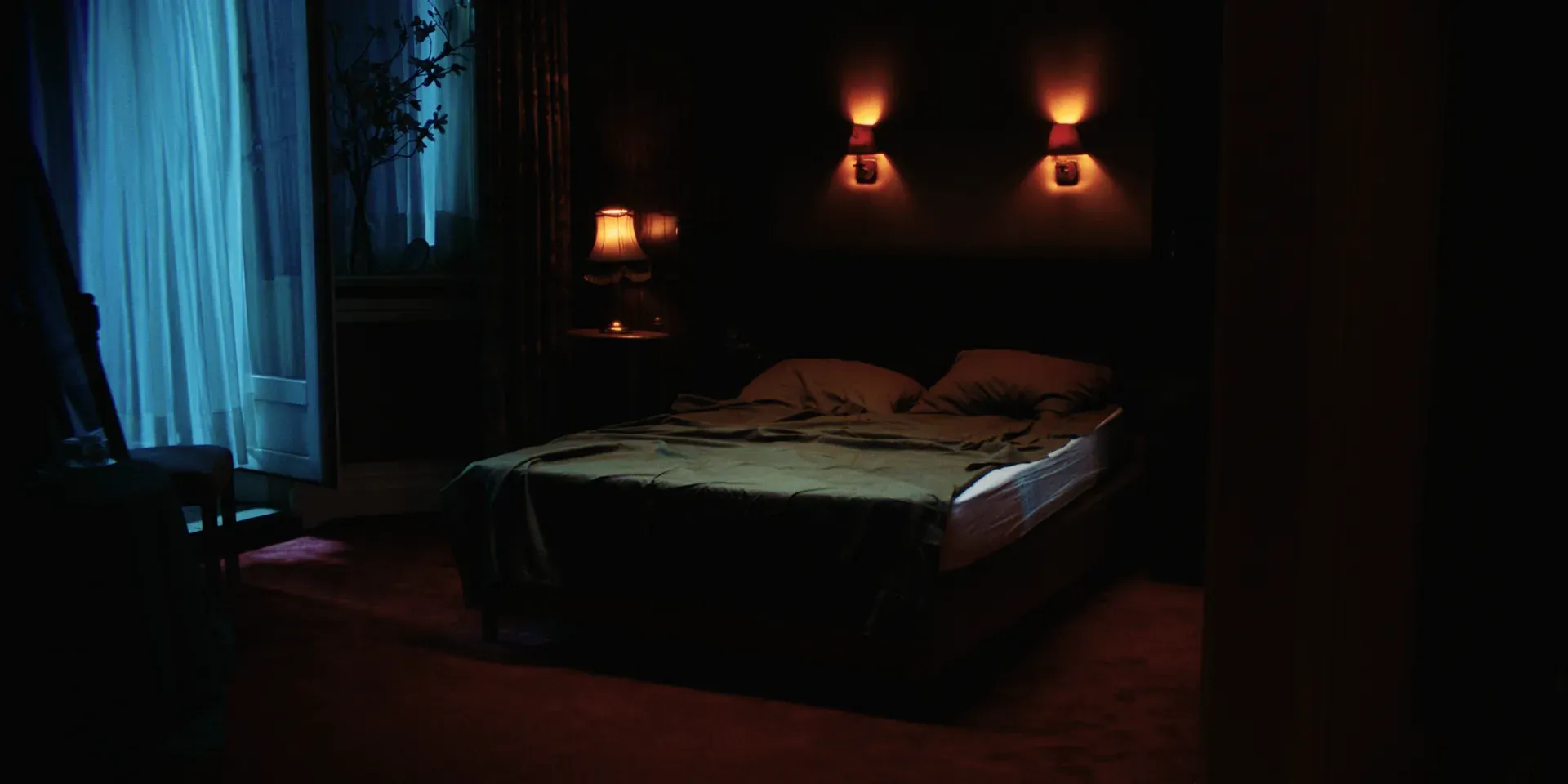 An empty bedroom washed in blue and red light in The Tears of Things